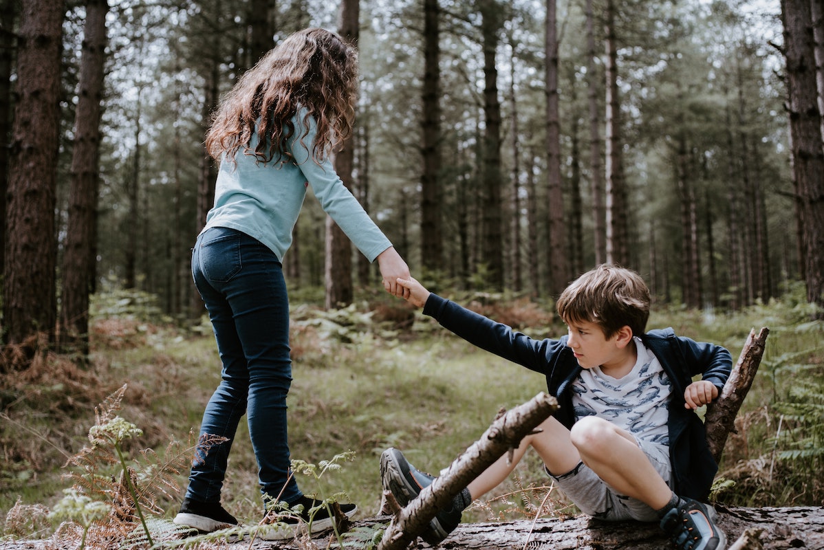 Two children playing in the woods